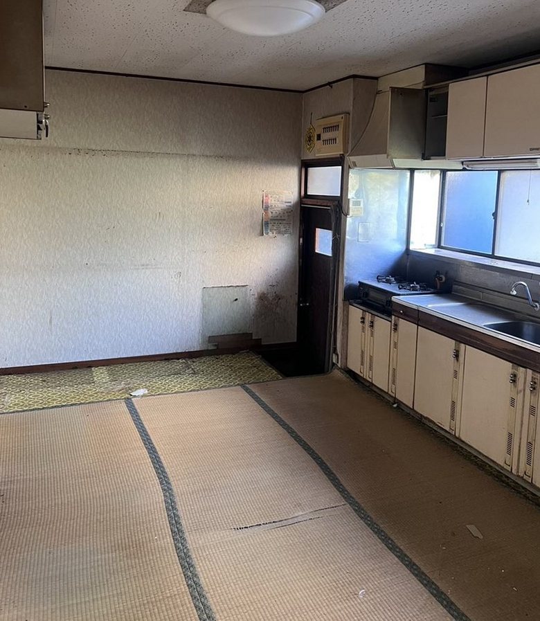 作業後：家財を運び出し、畳と台所が見える状態になった同じ部屋